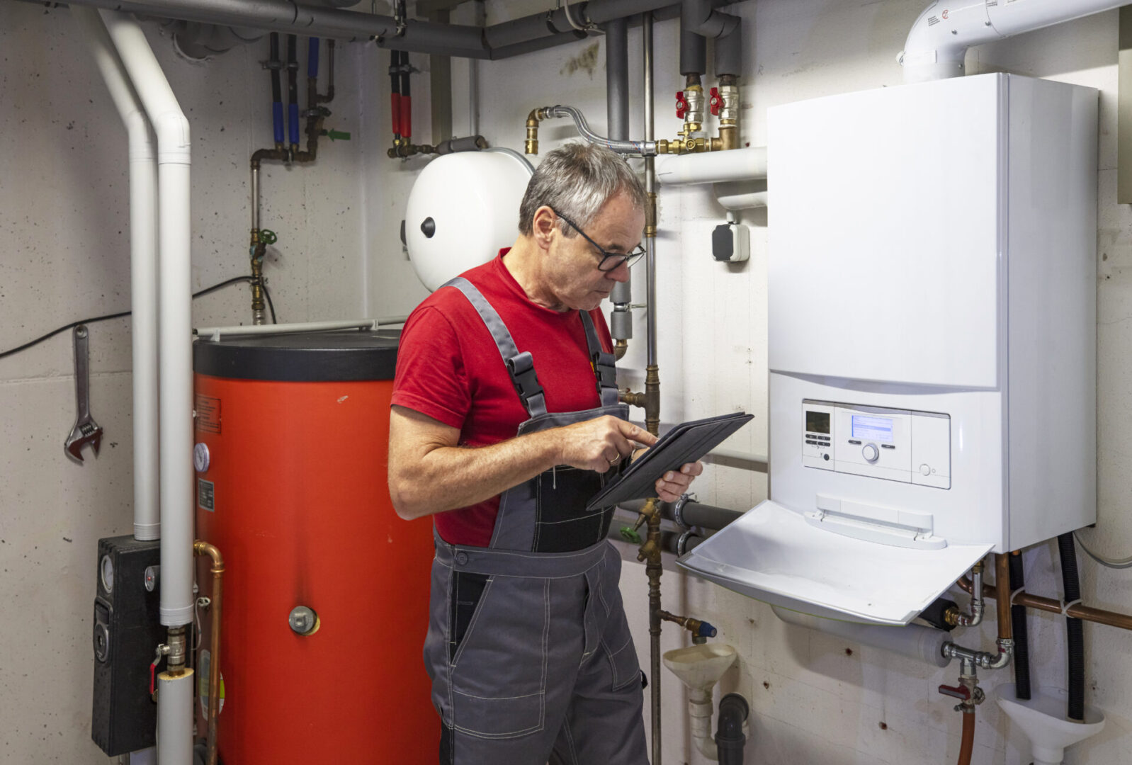 Engineer using tablet by boiler